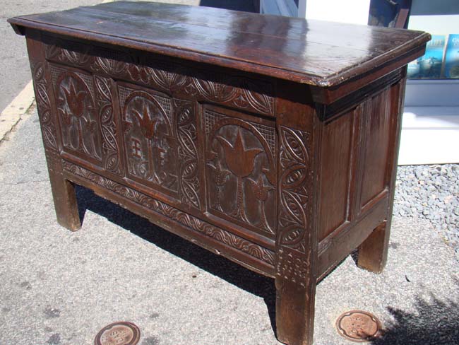 A fine late 17th century English oak coffer with tulip decoration and the initials I F and dated 1697